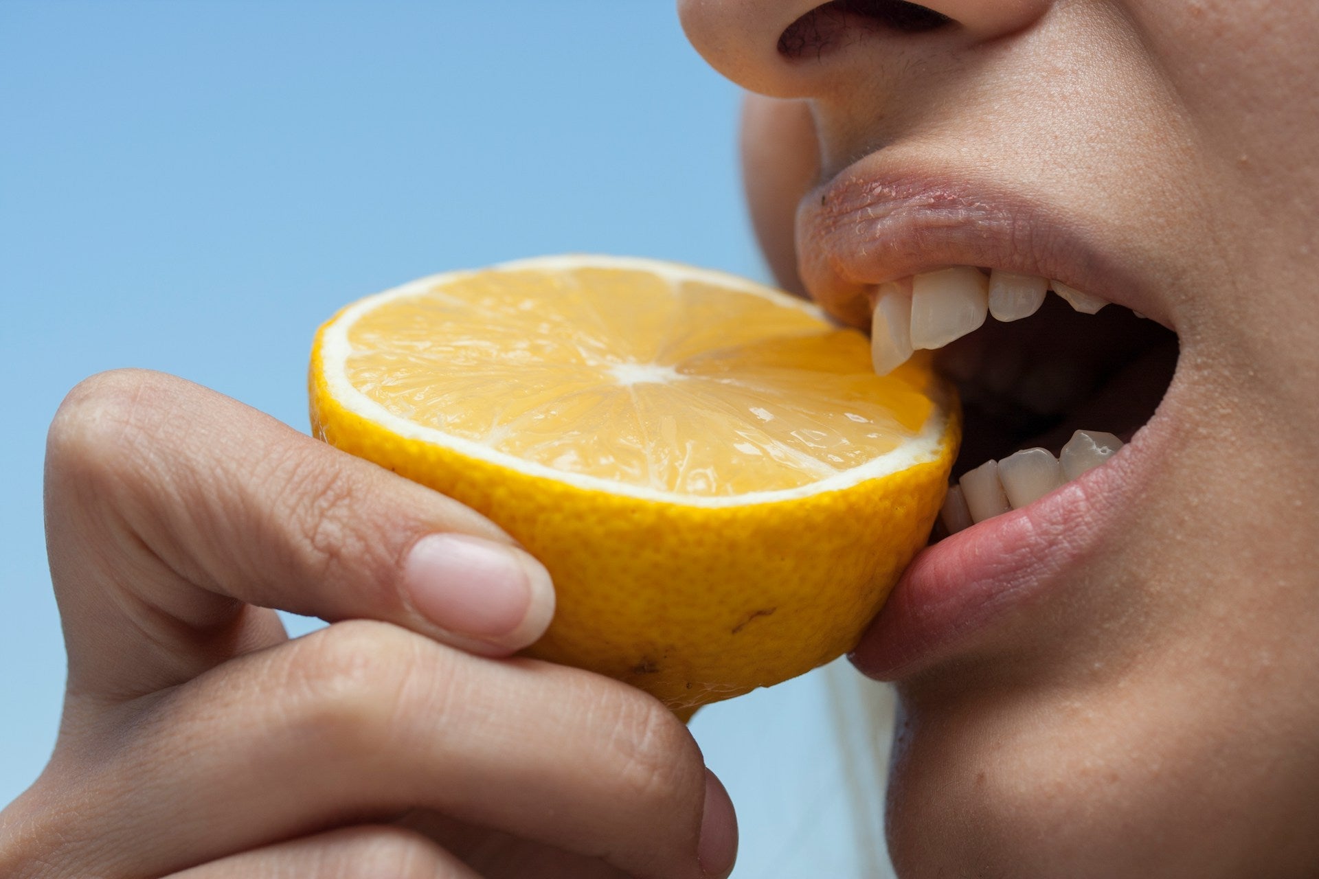 Mund beißt auf eine Orange